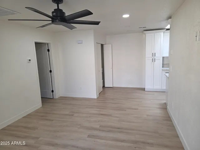 a view of a room with a ceiling fan and a wooden floor