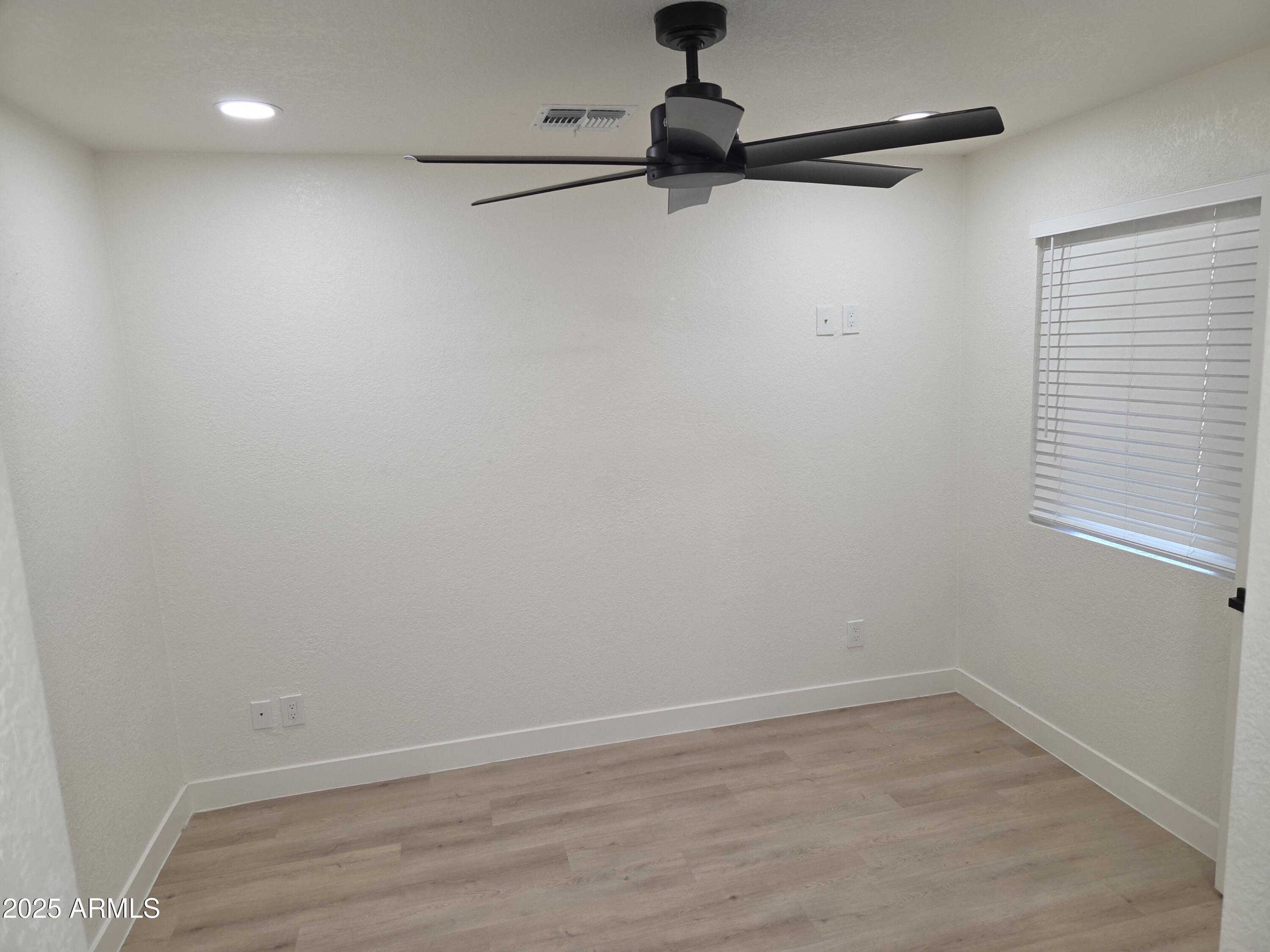 95 North Cooper Road, Unit 66 Chandler, AZ 85225 - Photo 18 of 25 a view of a room with a ceiling fan and a wooden floor