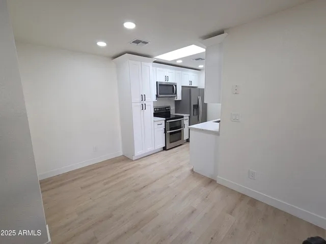 a view of a kitchen with a sink and a refrigerator