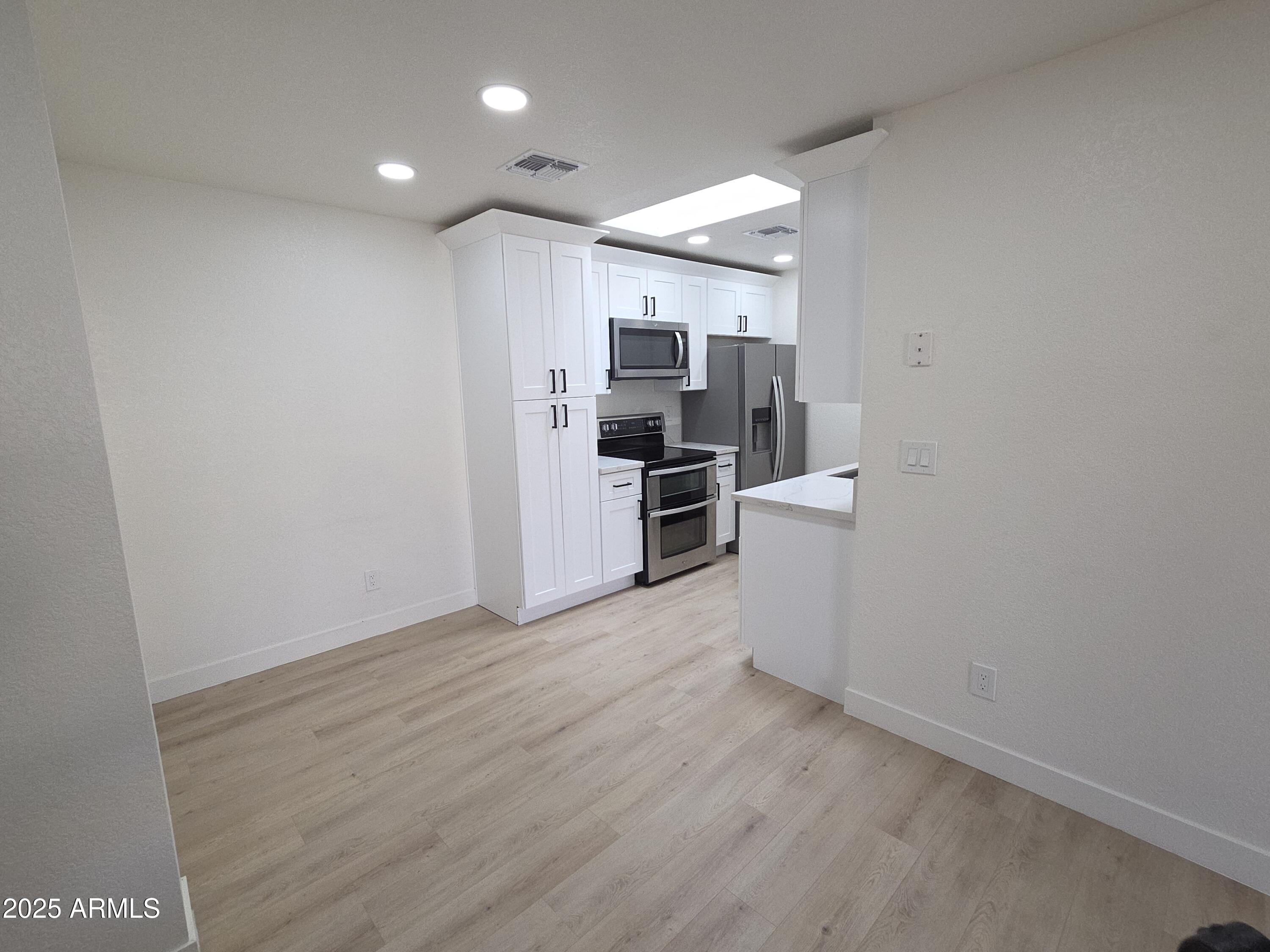 95 North Cooper Road, Unit 66 Chandler, AZ 85225 - Photo 3 of 25 a view of a kitchen with a sink and a refrigerator