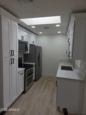 a kitchen with stainless steel appliances a sink stove and refrigerator