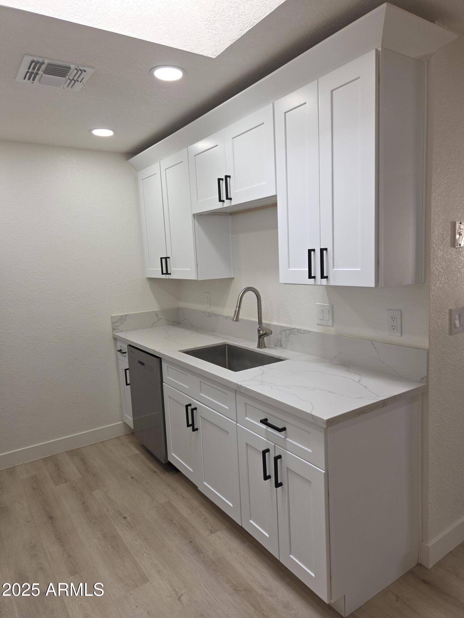 95 North Cooper Road, Unit 66 Chandler, AZ 85225 - Photo 5 of 25 a kitchen with white cabinets sink and dishwasher