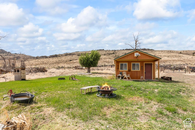 1054 East Jakes Pl Road Fremont, UT 84747 - Photo 14 of 18 View of yard with a fire pit, an outbuilding, and a rural view