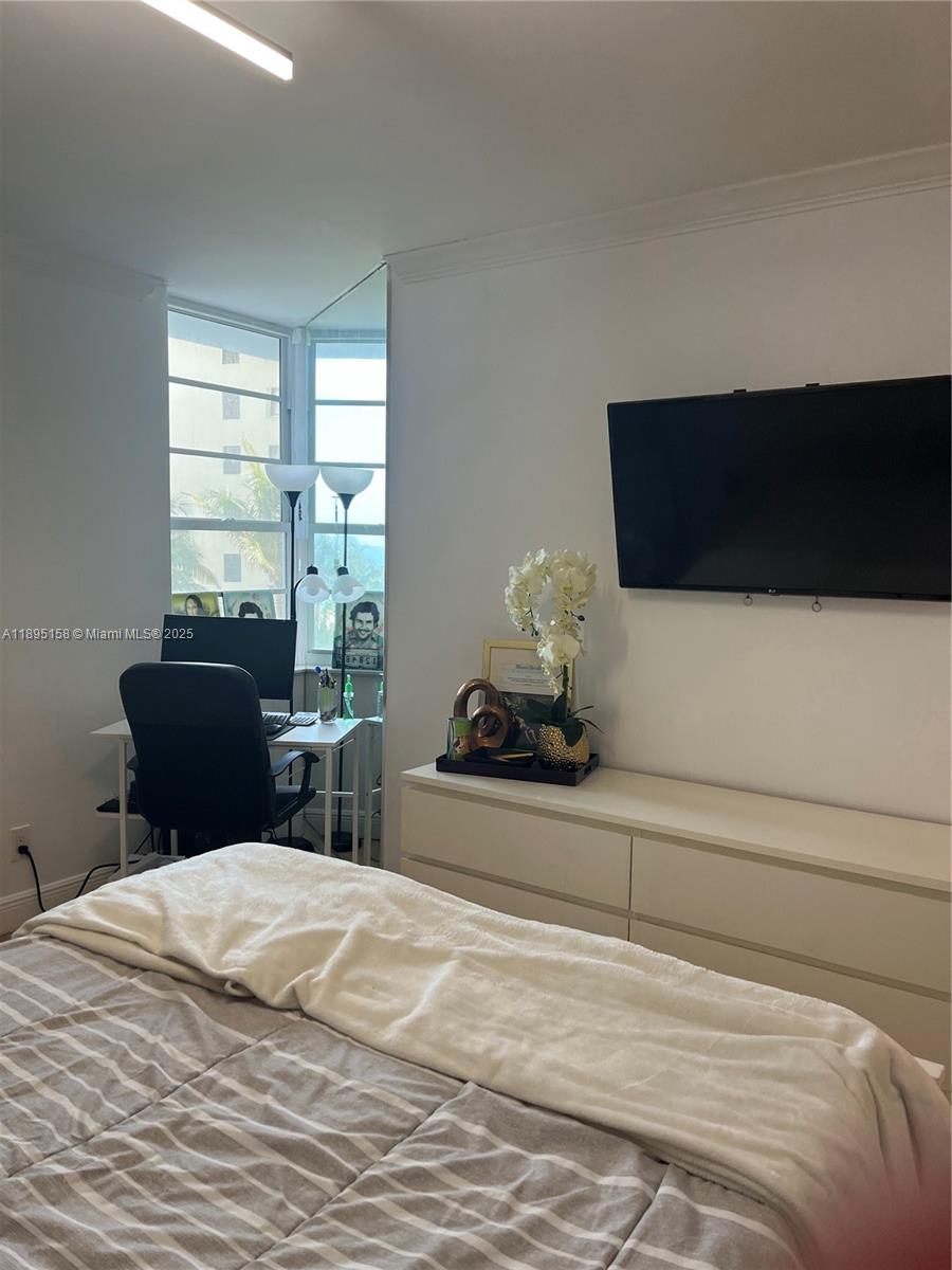 Miami Beach City Center Miami Beach, FL 33139 - Photo 15 of 15 a bedroom with a bed and a flat tv screen on dresser