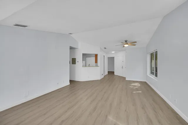 a view of empty room with wooden floor and window