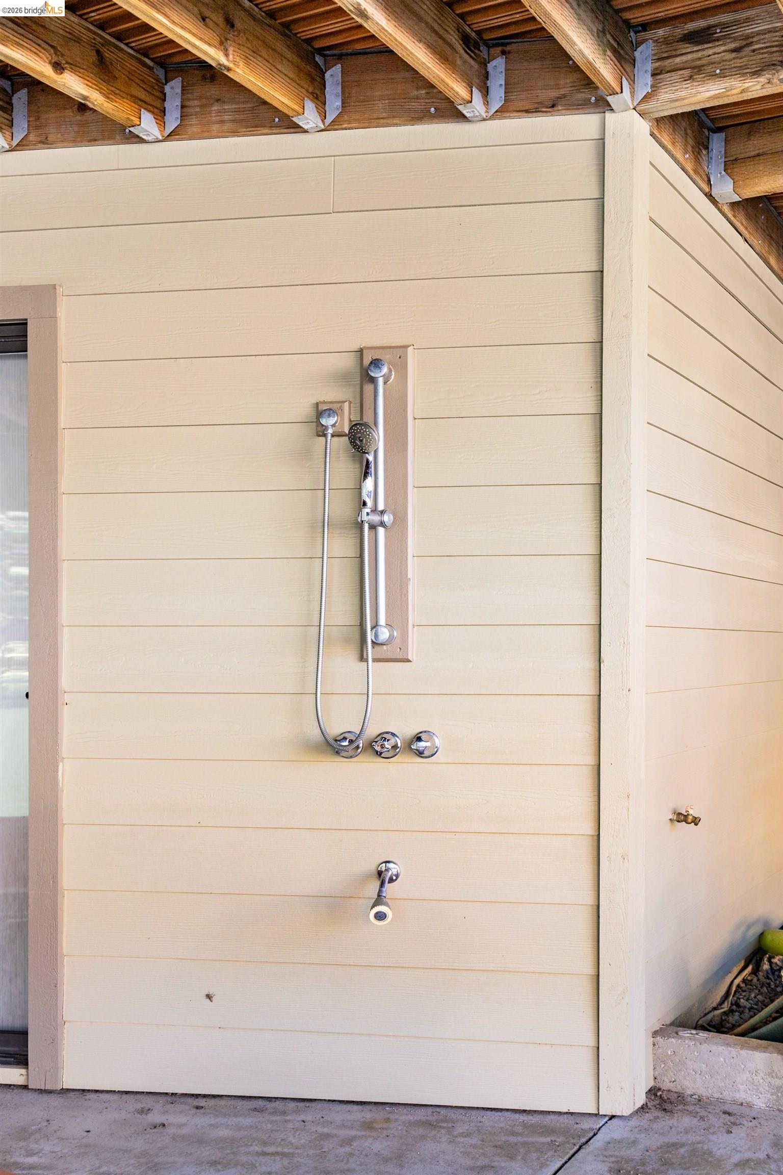 19711 Pleasantview Drive Groveland, CA 95321 - Photo 38 of 39 Outdoor shower with chrome fixtures and handheld sprayer, set against horizontal siding