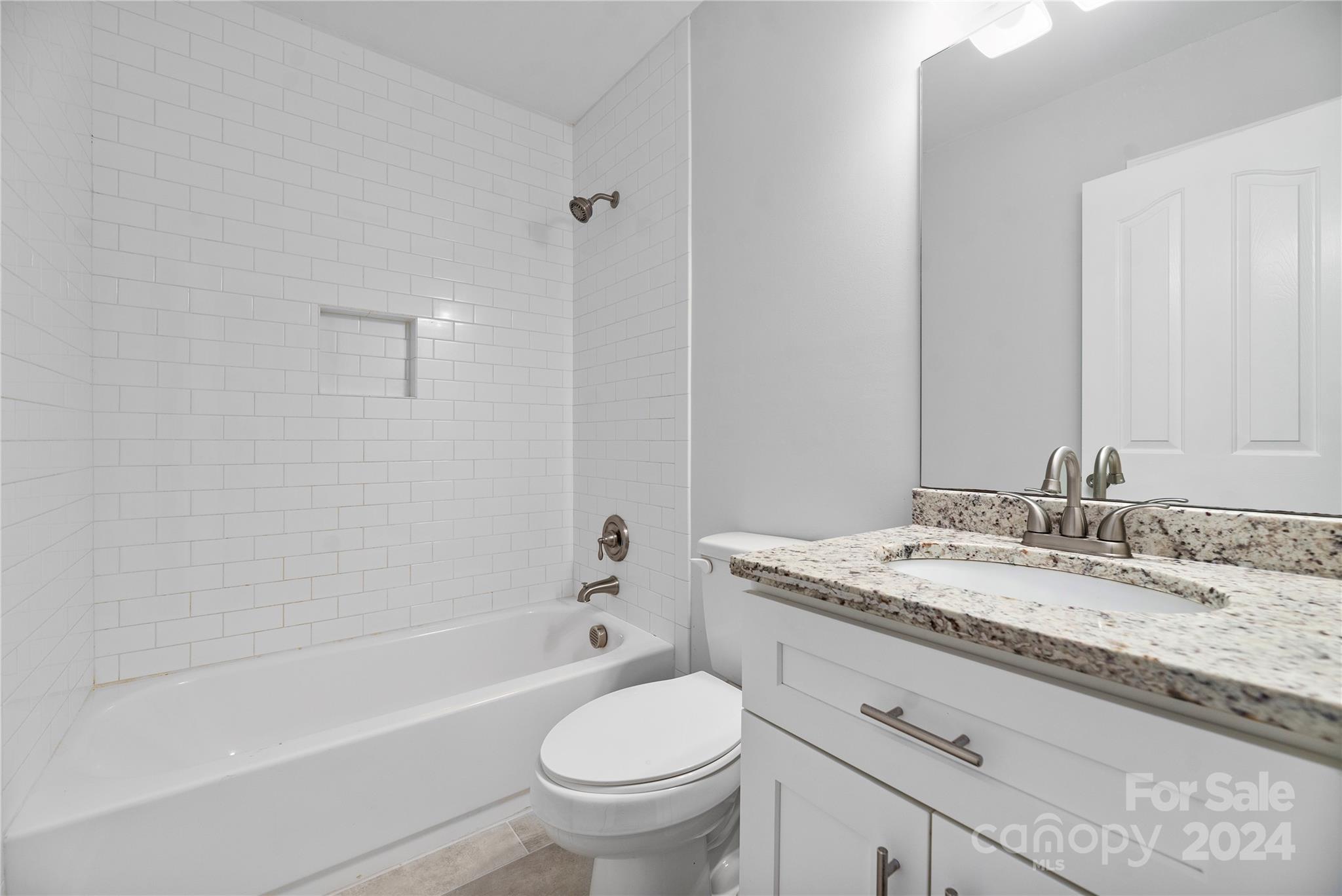 107 Planters Row Road Iron Station, NC 28080 - Photo 22 of 37 a bathroom with a granite countertop sink toilet mirror and bathtub