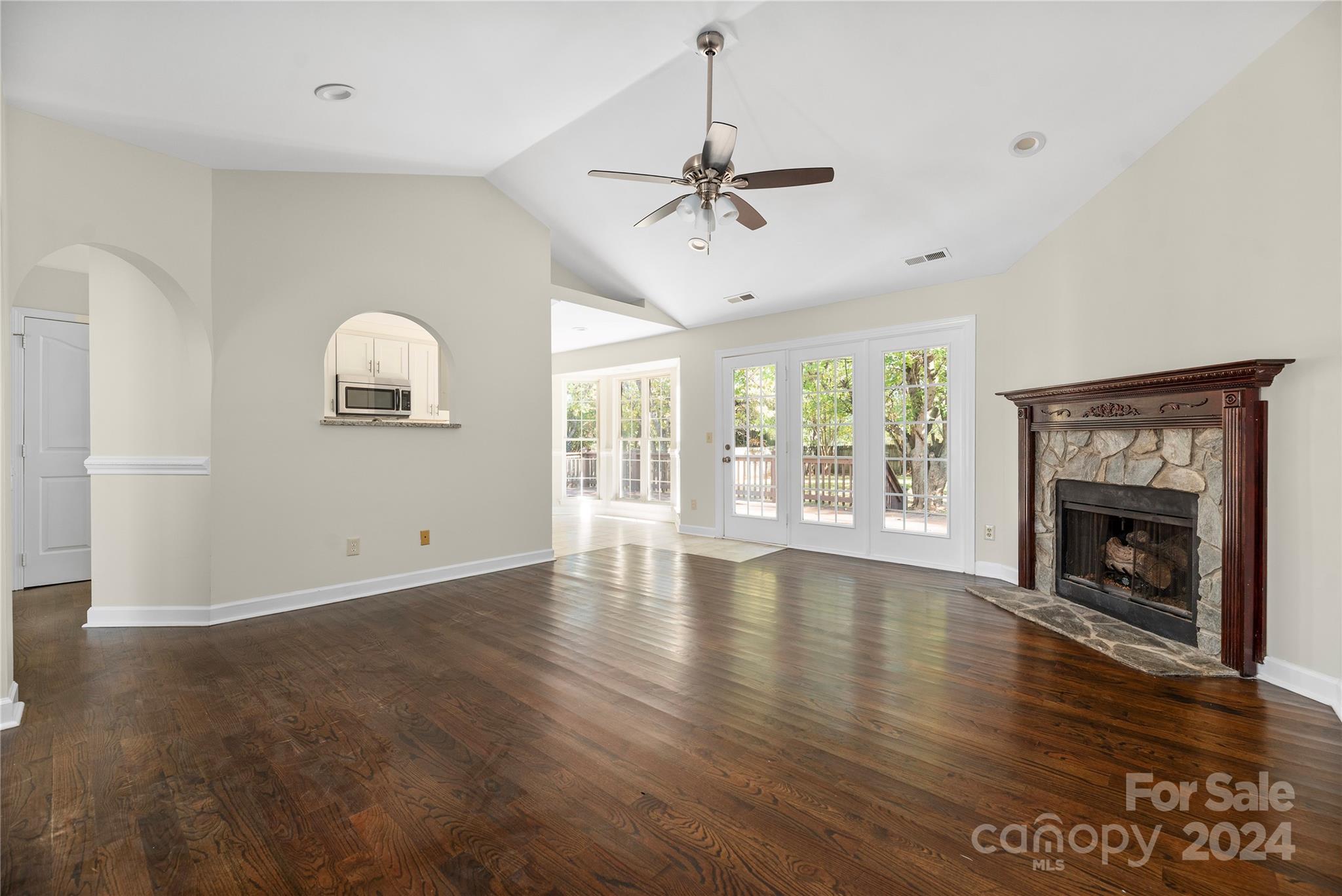 107 Planters Row Road Iron Station, NC 28080 - Photo 5 of 37 an empty room with windows fireplace and wooden floor