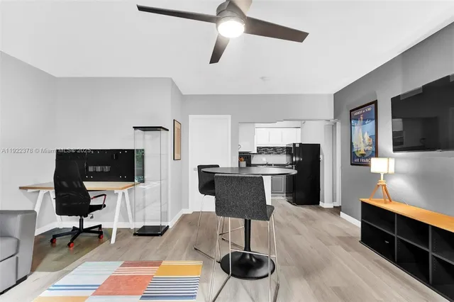 a kitchen with stainless steel appliances kitchen island granite countertop a stove top oven a sink a dining table and chairs with wooden floor