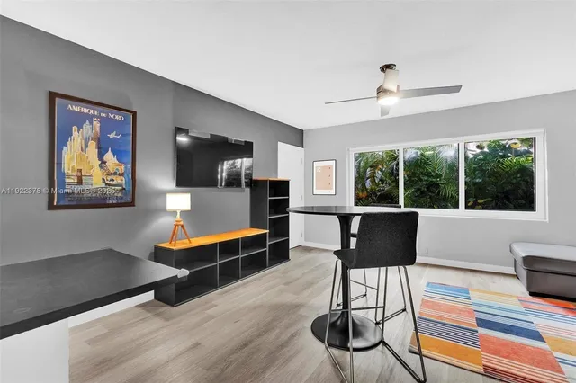 a living room with furniture a window and a flat screen tv