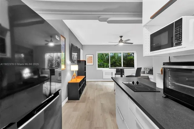 a dining hall with couches a flat screen tv and kitchen view