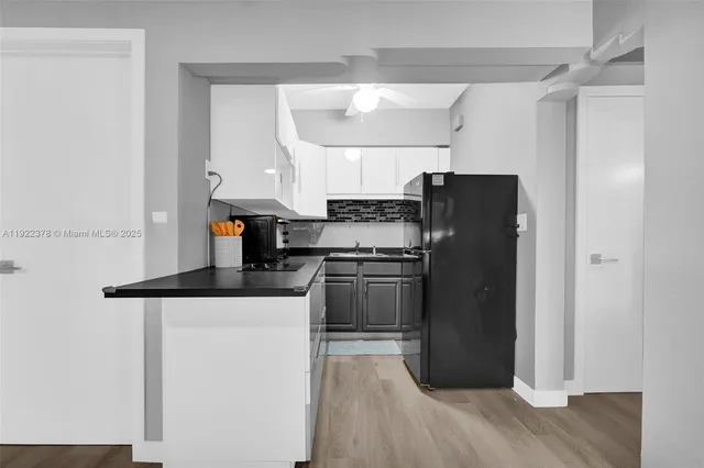 a kitchen with a refrigerator a stove and wooden floor