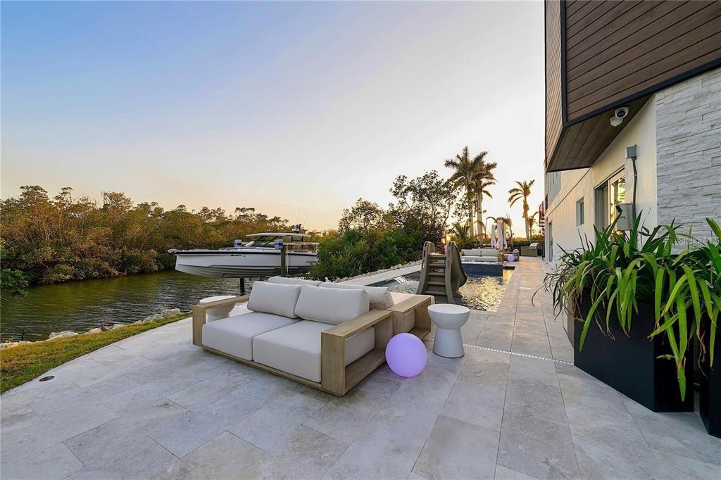 1406 Tangier Way Sarasota, FL 34239 - Photo 13 of 58 a view of a patio with couches and a table and chairs with wooden floor and fence