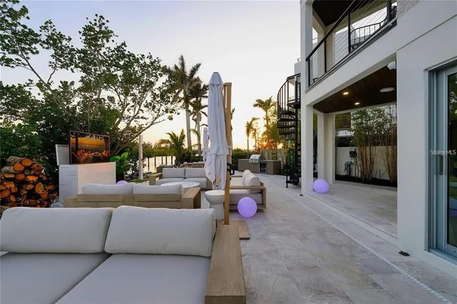 a view of a patio with couches and chairs under an umbrella