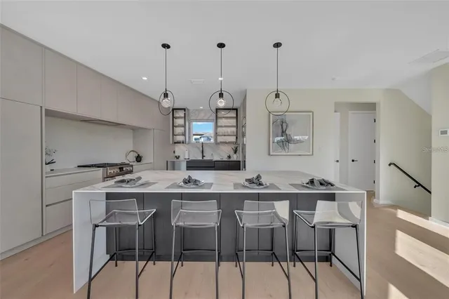 a kitchen with stainless steel appliances granite countertop a stove a sink and a wooden floors