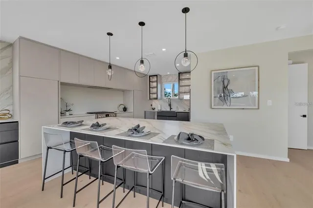 a kitchen with stainless steel appliances granite countertop a sink a stove and a wooden floors