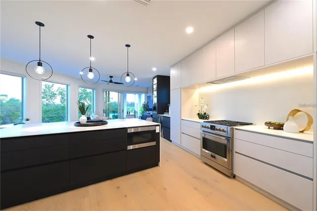 a living room with furniture kitchen view and a large window