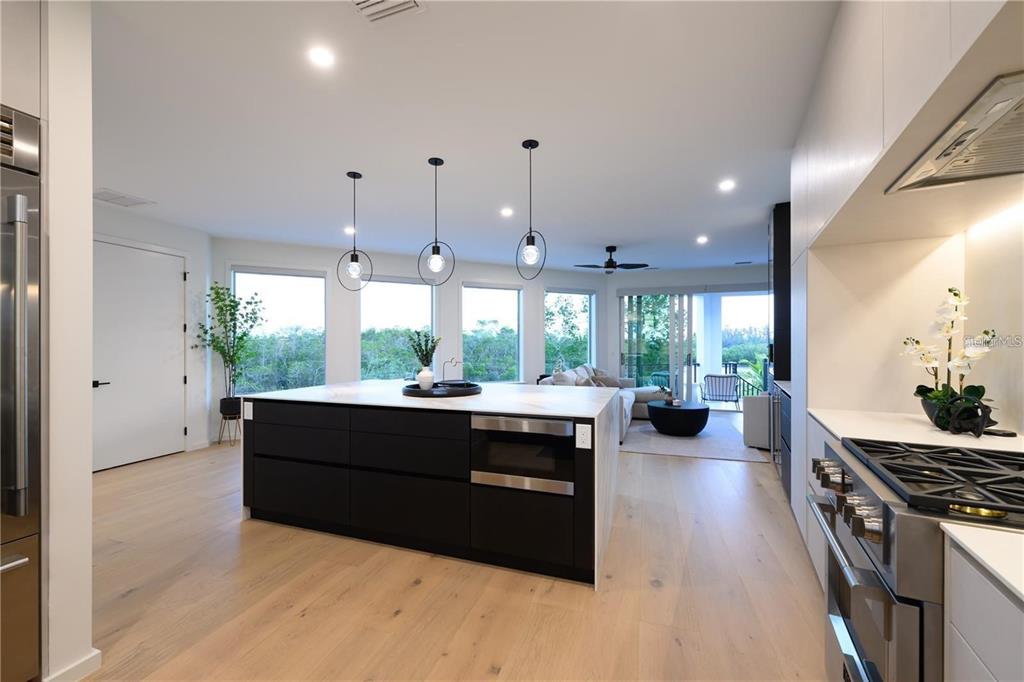 1406 Tangier Way Sarasota, FL 34239 - Photo 33 of 58 a large kitchen with kitchen island a stove a sink dishwasher and wooden cabinets