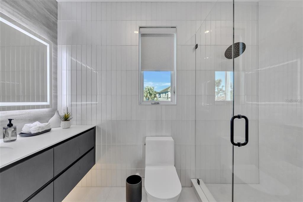 1406 Tangier Way Sarasota, FL 34239 - Photo 38 of 58 a bathroom with a granite countertop sink a toilet and shower