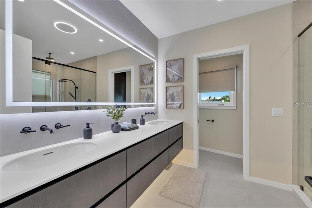 1406 Tangier Way Sarasota, FL 34239 - Photo 43 of 58 a en suite bathroom with double vanity sinks and a mirror