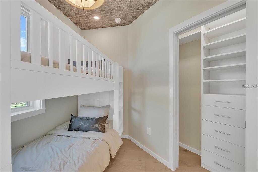 1406 Tangier Way Sarasota, FL 34239 - Photo 46 of 58 a bedroom with a bed and a walk in closet