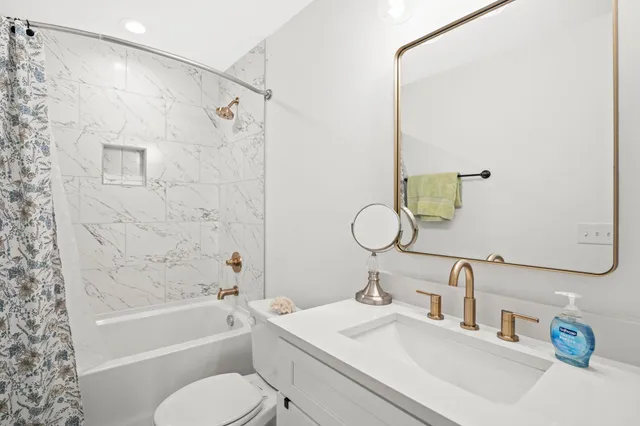 a bathroom with a sink mirror toilet and bathtub