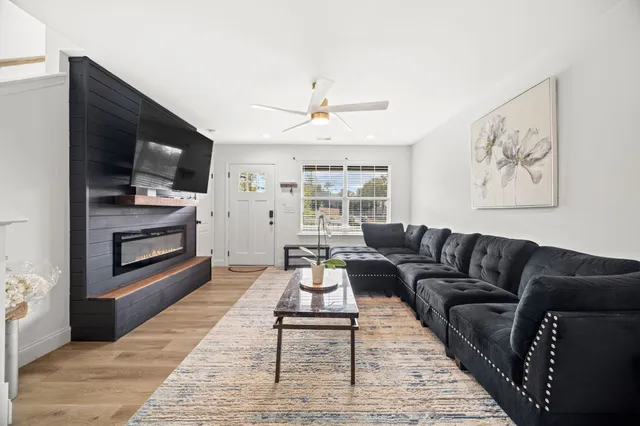 a living room with furniture a flat screen tv and a fireplace