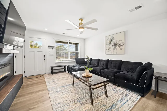 a living room with furniture a fireplace and a flat screen tv