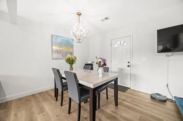 a view of a dining room with furniture wooden floor and chandelier