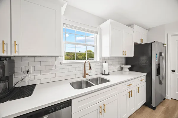a kitchen with stainless steel appliances white cabinets and a sink