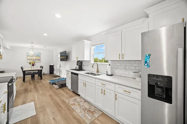 a kitchen with white cabinets and stainless steel appliances