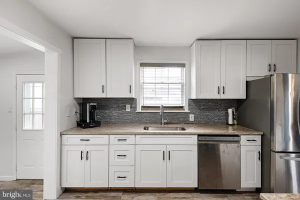 a kitchen with appliances a sink and cabinets