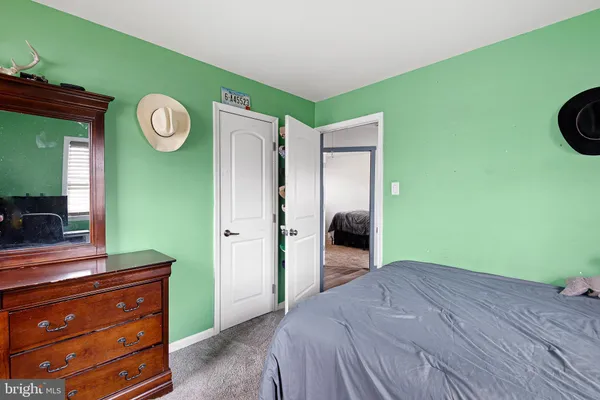 a bedroom with a bed and a mirror on the dresser