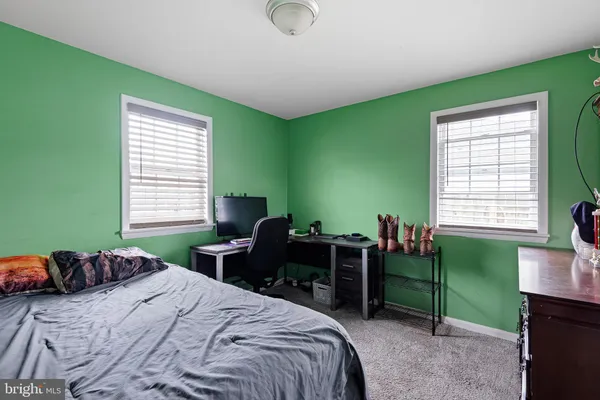 a bedroom with a bed and a dresser next to a window