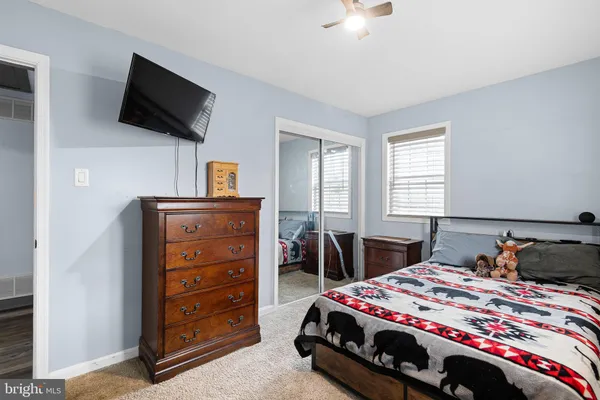 a bedroom with a bed and a flat tv screen on wall