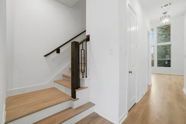 a view of an empty room with wooden floor and cabinet