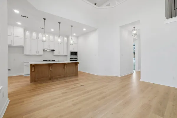 a large kitchen with kitchen island a sink stainless steel appliances and cabinets