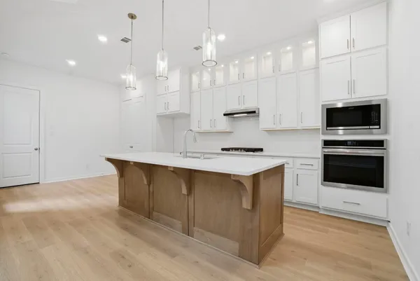 a kitchen with kitchen island a sink stainless steel appliances and white cabinets