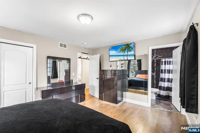 a bedroom with a bed dresser and a flat screen tv