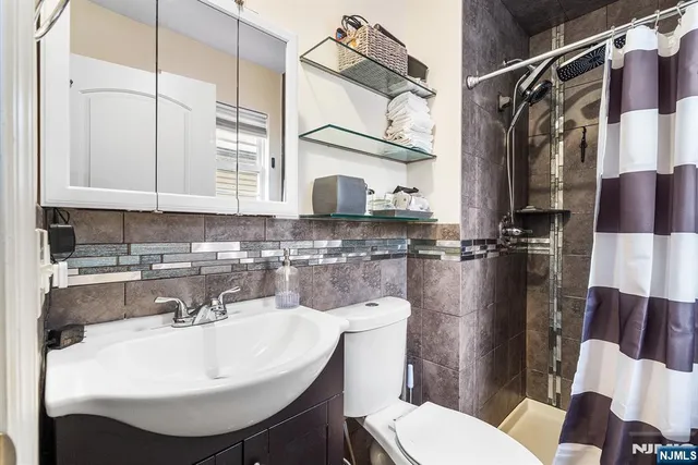 a bathroom with a sink a toilet and a mirror