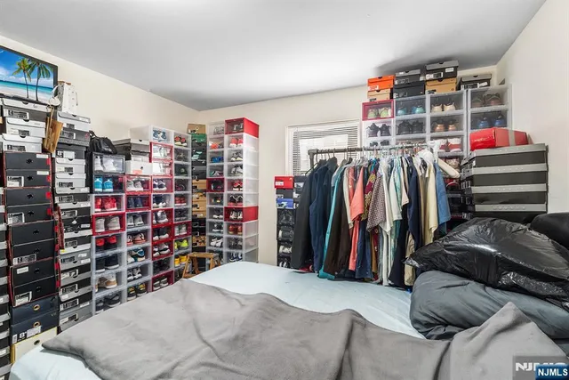 a view of walk in closet with clothes and shoes