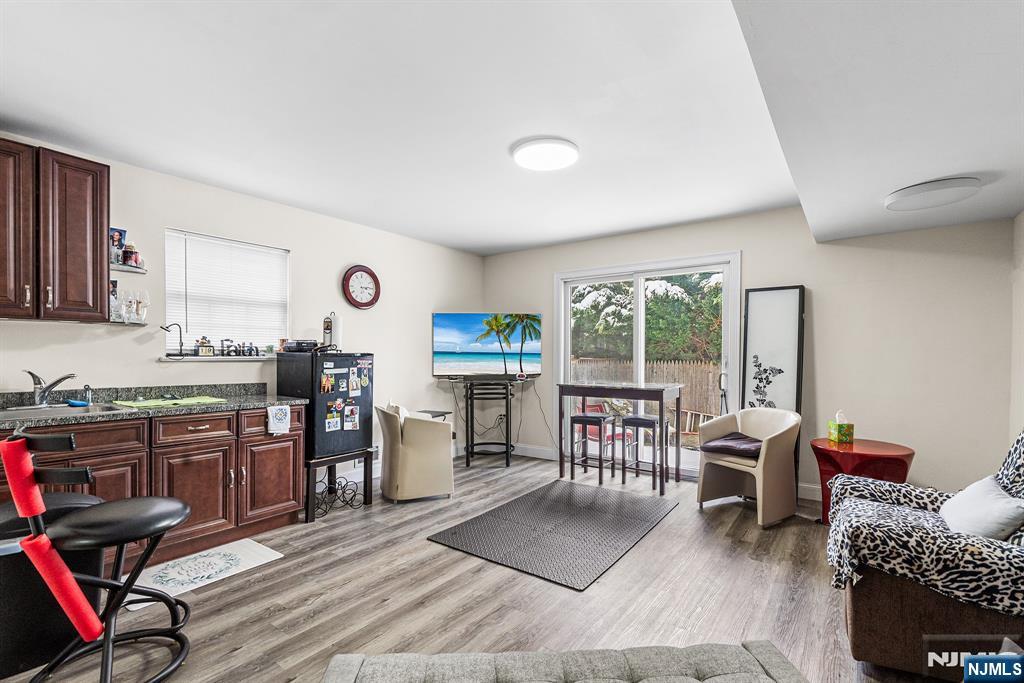 128 Baltimore Avenue Hillside, NJ 07205 - Photo 29 of 50 a open kitchen with stainless steel appliances granite countertop a stove top oven a refrigerator a dining table and chairs with wooden floor
