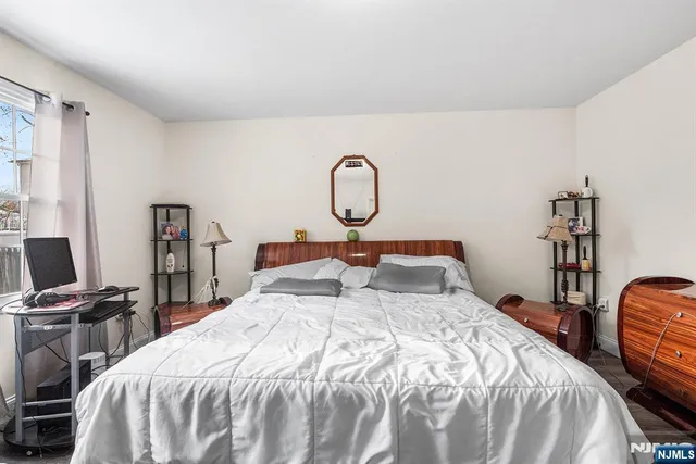 a bedroom with bed a table and a piano