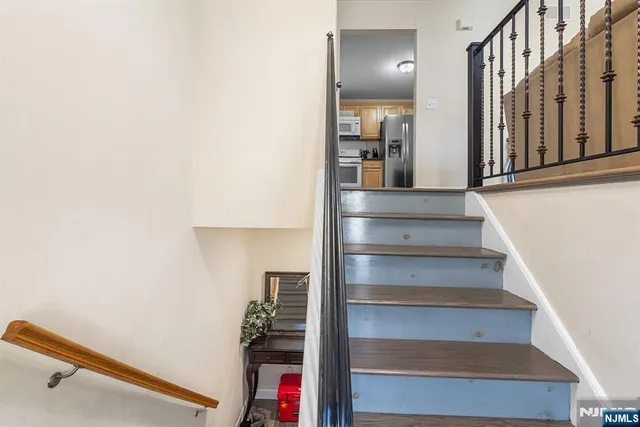 a kitchen with stainless steel appliances granite countertop a refrigerator a stove and a sink with large window