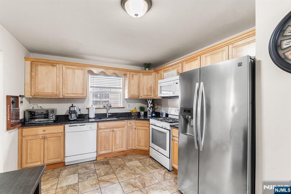 128 Baltimore Avenue Hillside, NJ 07205 - Photo 43 of 50 a kitchen with stainless steel appliances granite countertop a refrigerator sink and cabinets