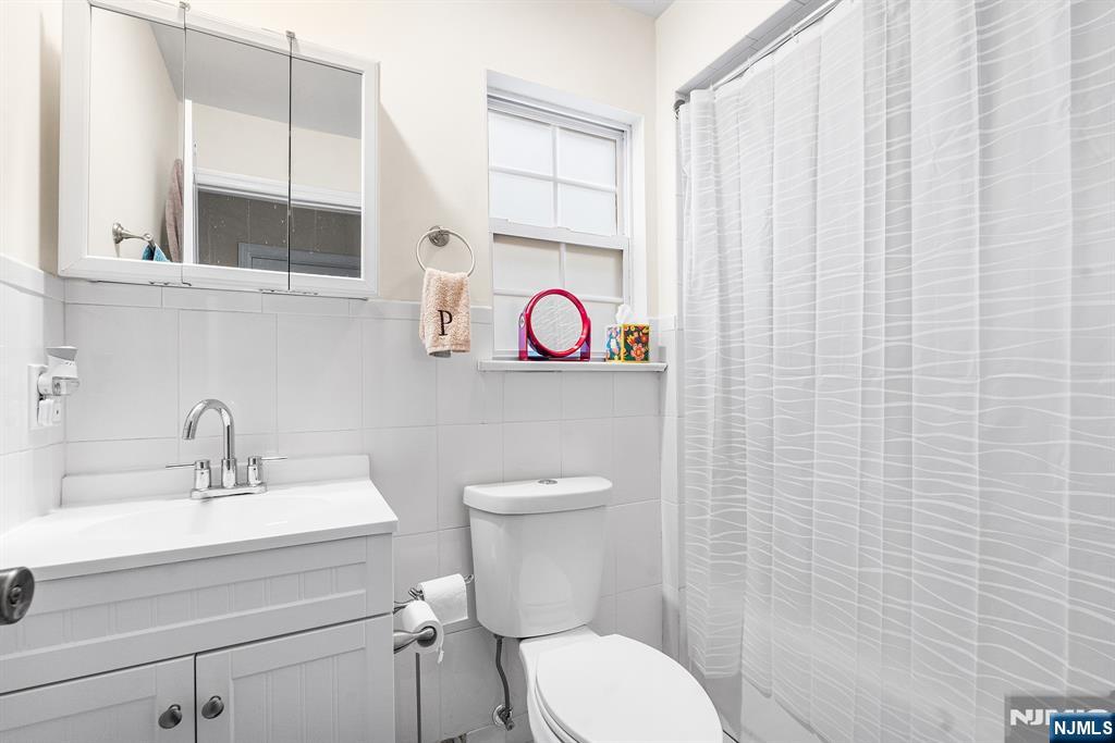 128 Baltimore Avenue Hillside, NJ 07205 - Photo 45 of 50 a bathroom with a toilet a sink and a mirror