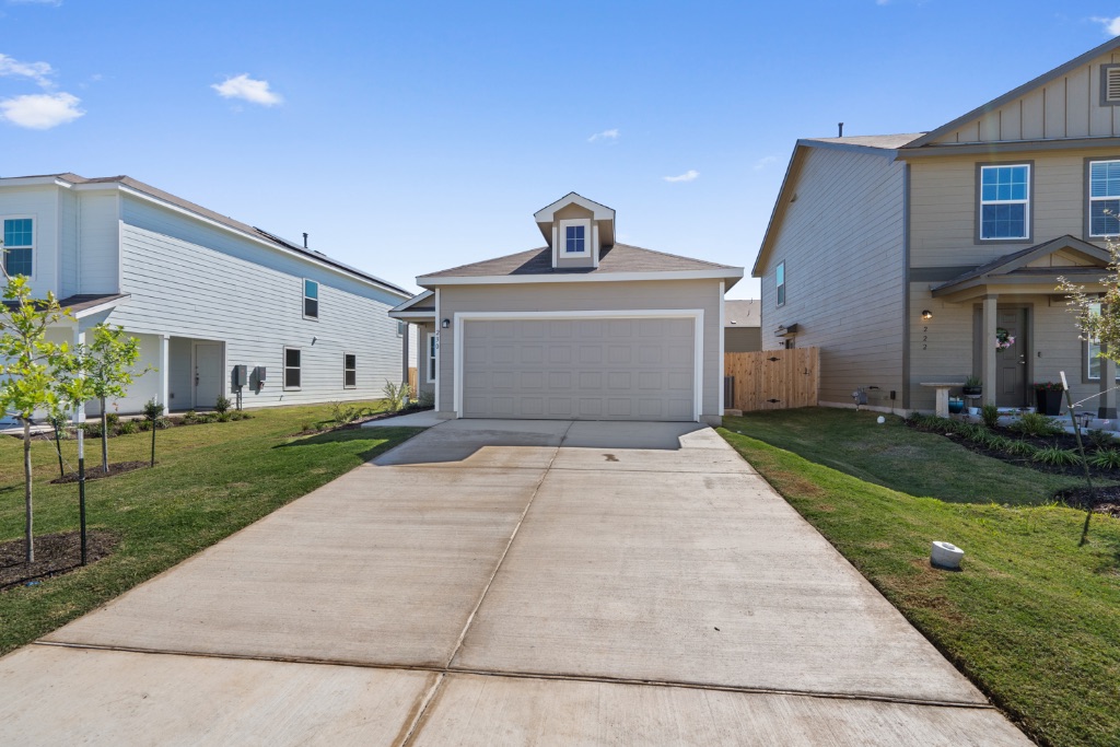 a front view of a house with a yard and a garage