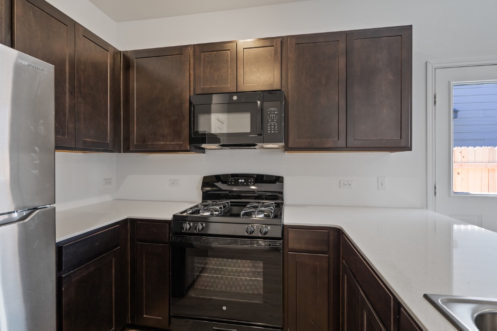 230 Gabbro Gardens Maxwell, TX 78656 - Photo 9 of 24 a kitchen with a refrigerator stove and microwave