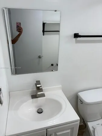 a bathroom with a sink a toilet a mirror and vanity