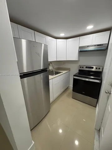 a kitchen with a refrigerator a stove and a sink